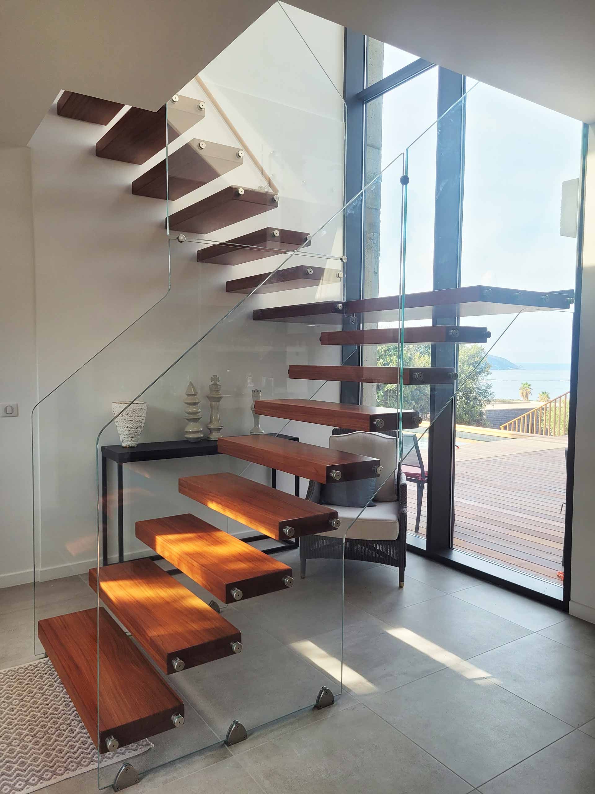 Escalier en bois brun et rembarde en verre dans une propriété