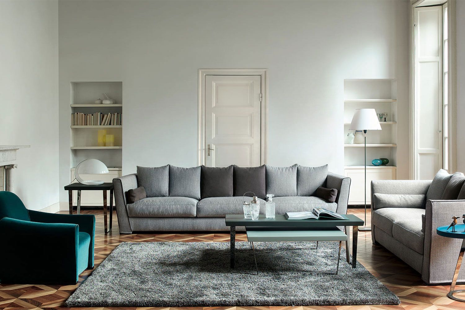 Ensemble de canapé et fauteuils gris et bleu canard dans un séjour aux murs clairs