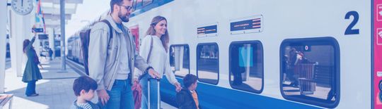 Une famille sur un quai de gare montant dans un train