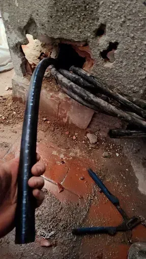 Una persona sostiene una manguera negra en su mano.