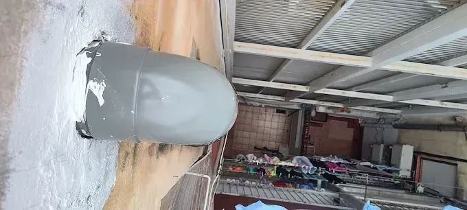 Una tubería gris está fijada a una pared de un edificio.