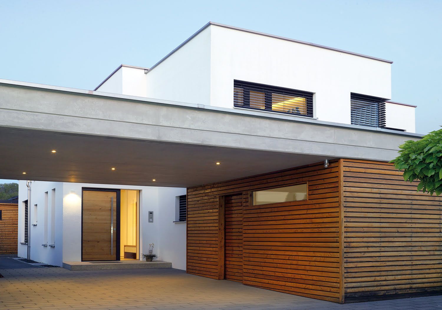 Modernes weißes Haus mit Carport, holzvertäfelt, und einer Holz-Eingangstür