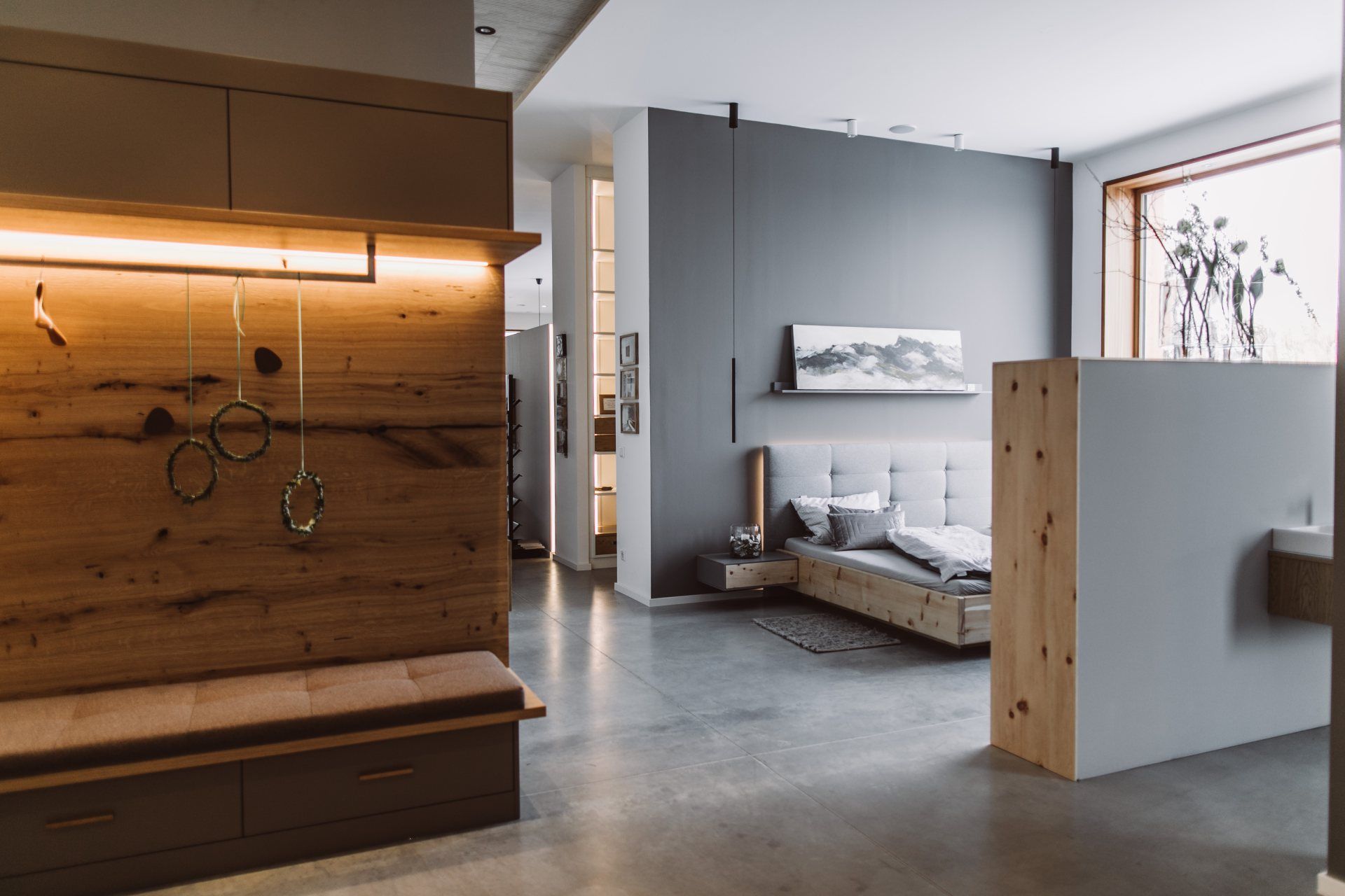 Ausstellung Häckl: Garderobe mit Beleuchtung und Bett im Hintergrund