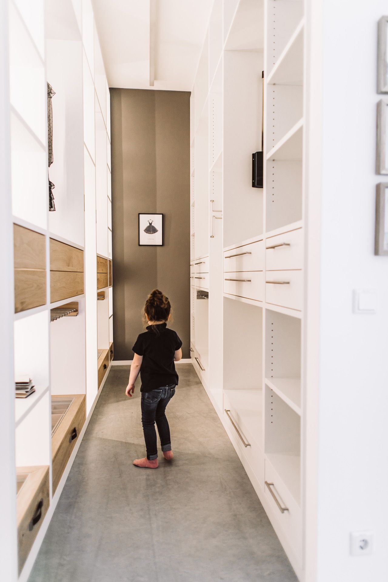 Showroom Häckl - kleines Mächen läuft durch einen weißen begehbaren Kleiderschrank