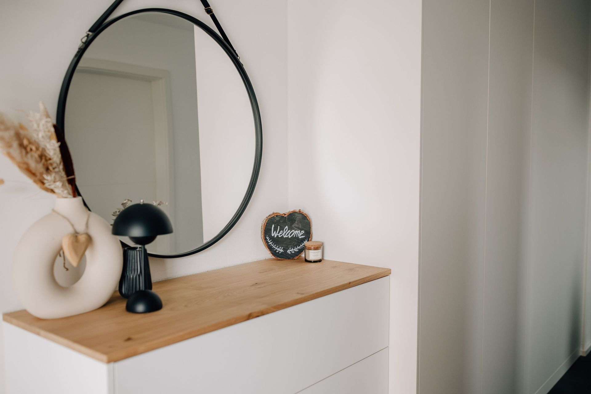 Flur mit weißen Schränken und Holzakzent, dazu moderne Dekoration