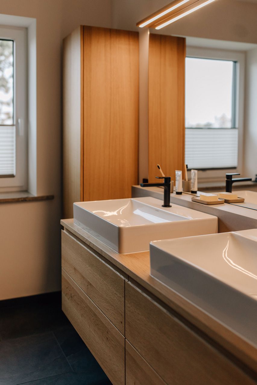 Schreinerei Häckl - Badezimmer mit zwei großen Waschbecken und schwarzer Armatur