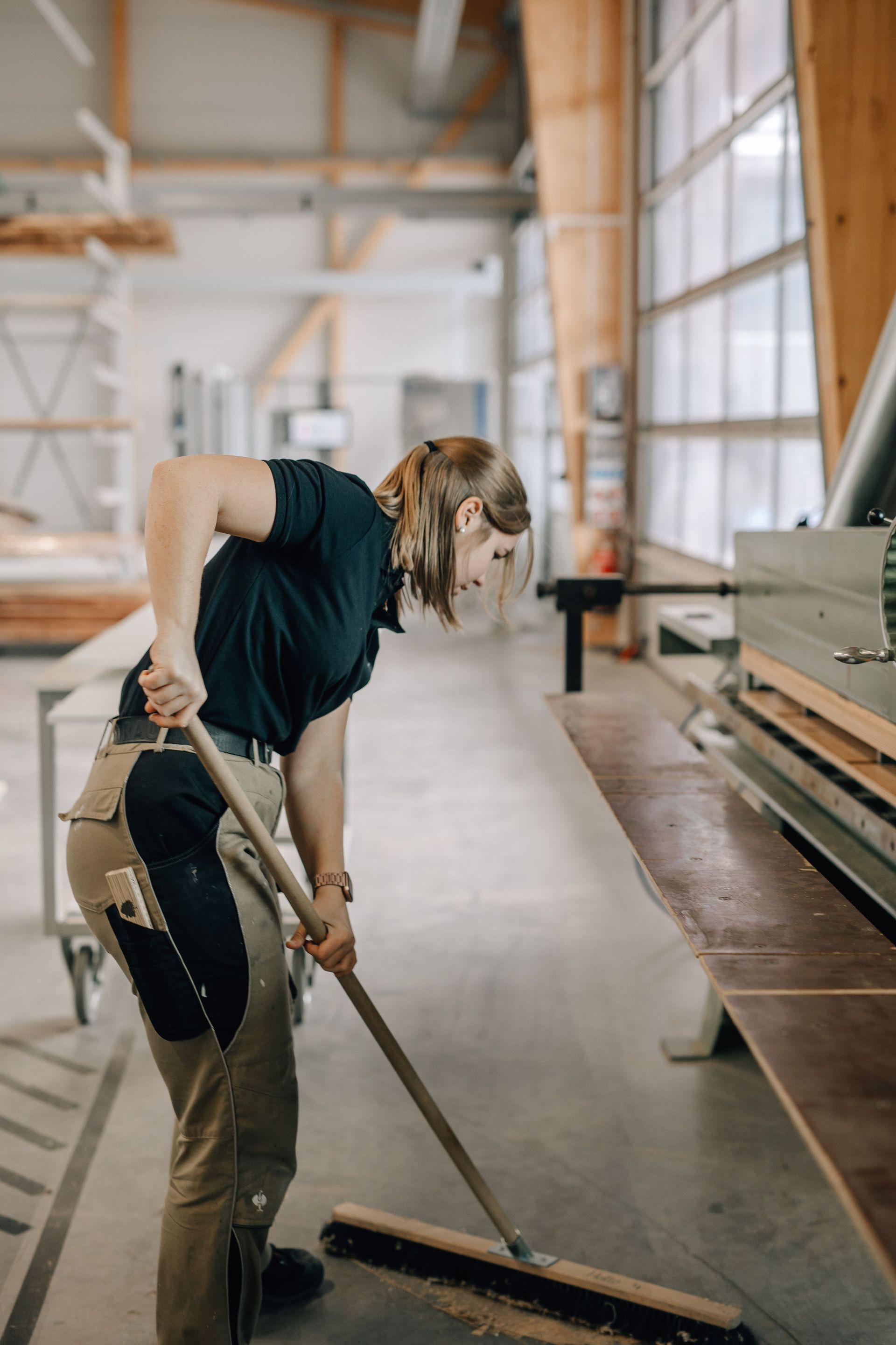Mitarbeiterin Häckl fegt die Sägespäne weg