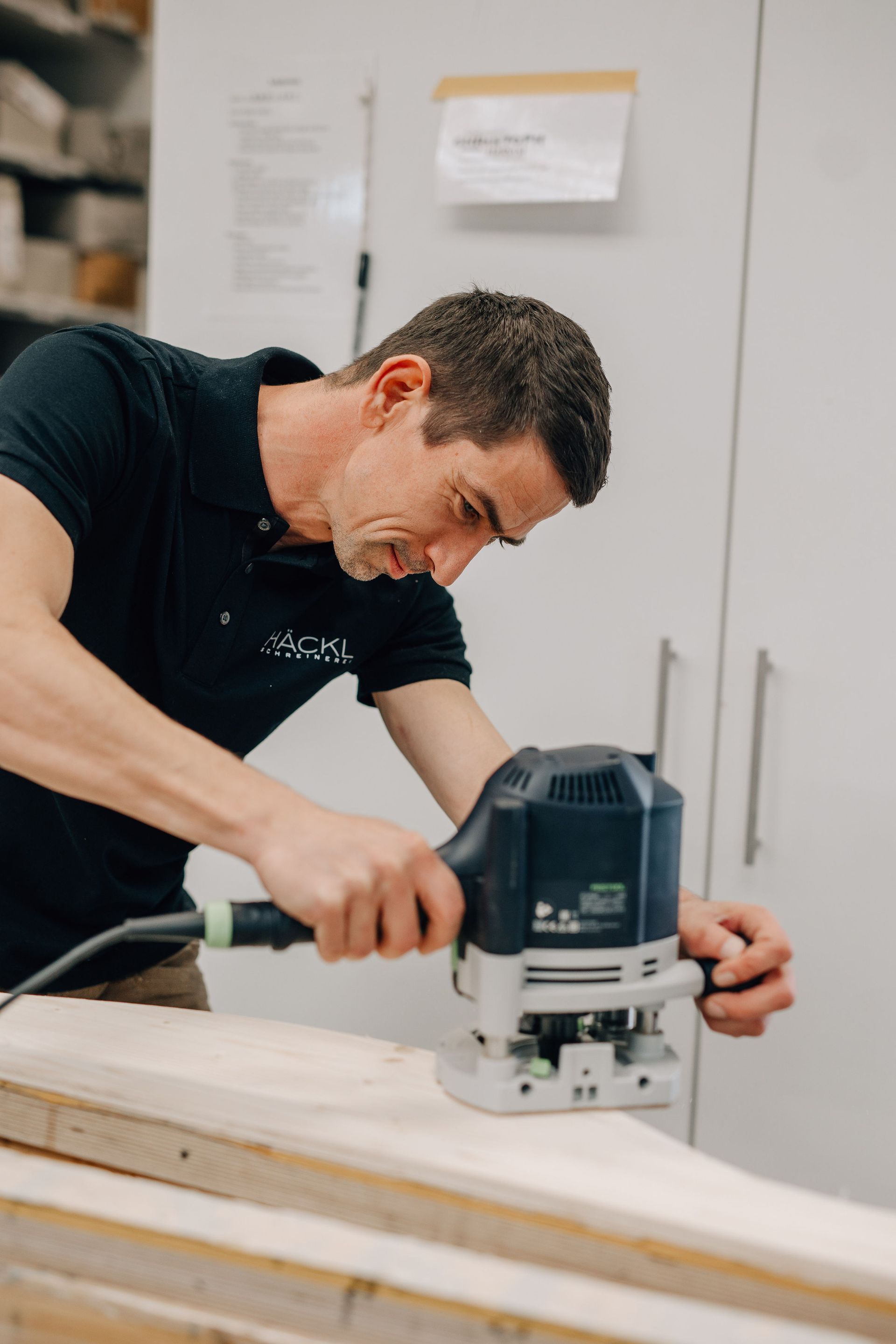 Schreiner arbeitet mit einer Maschine an einem Holzstück