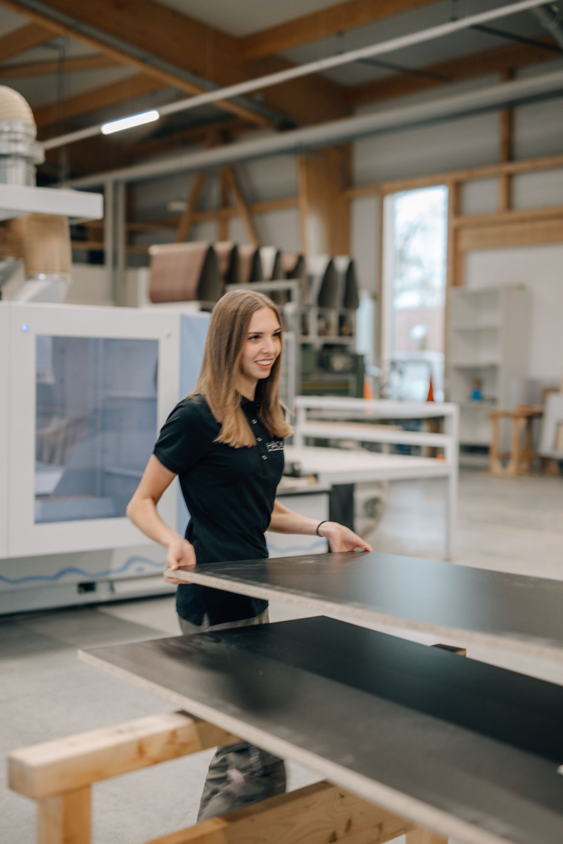 Häckl Mitarbeiterin mit einer Holzplatte