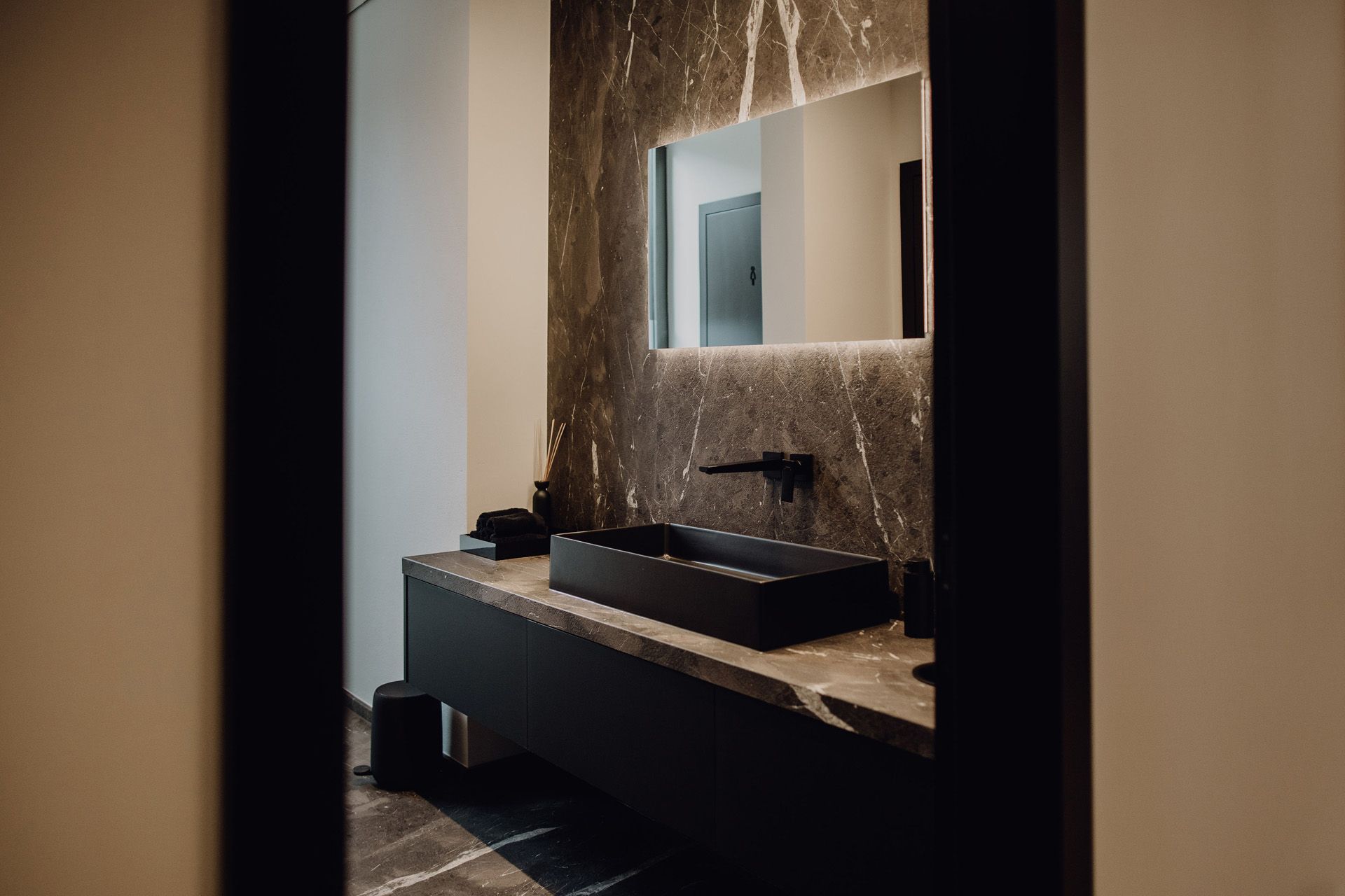 Schreinerei Häckl - hochwertiges dunkles Badezimmer mit Marmor-Akzenten