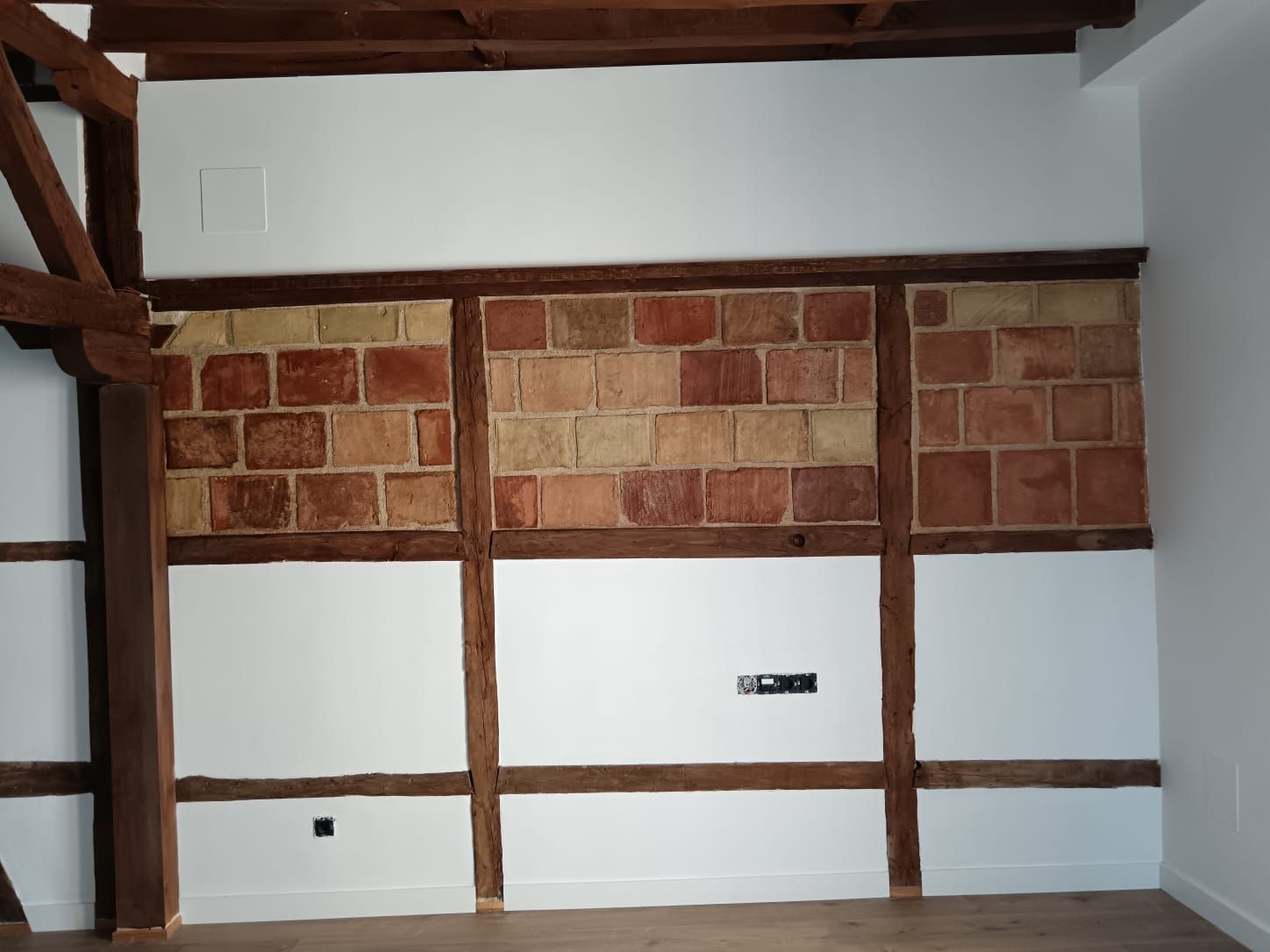 Un pasillo con suelo de madera y una puerta.