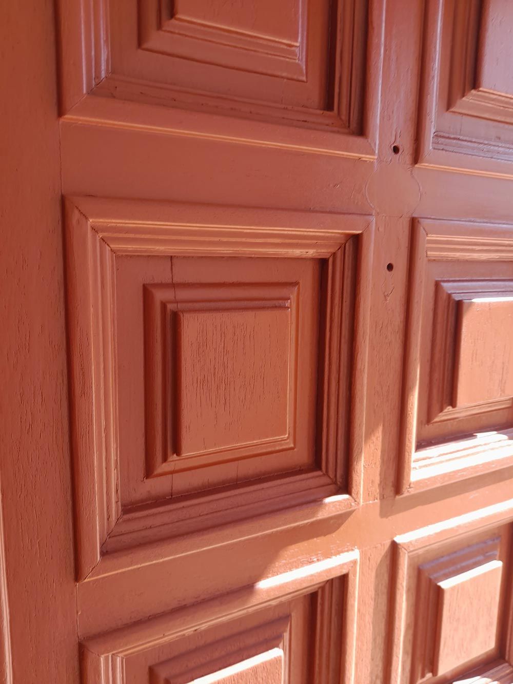 Un primer plano de una puerta de madera con cuadrados.