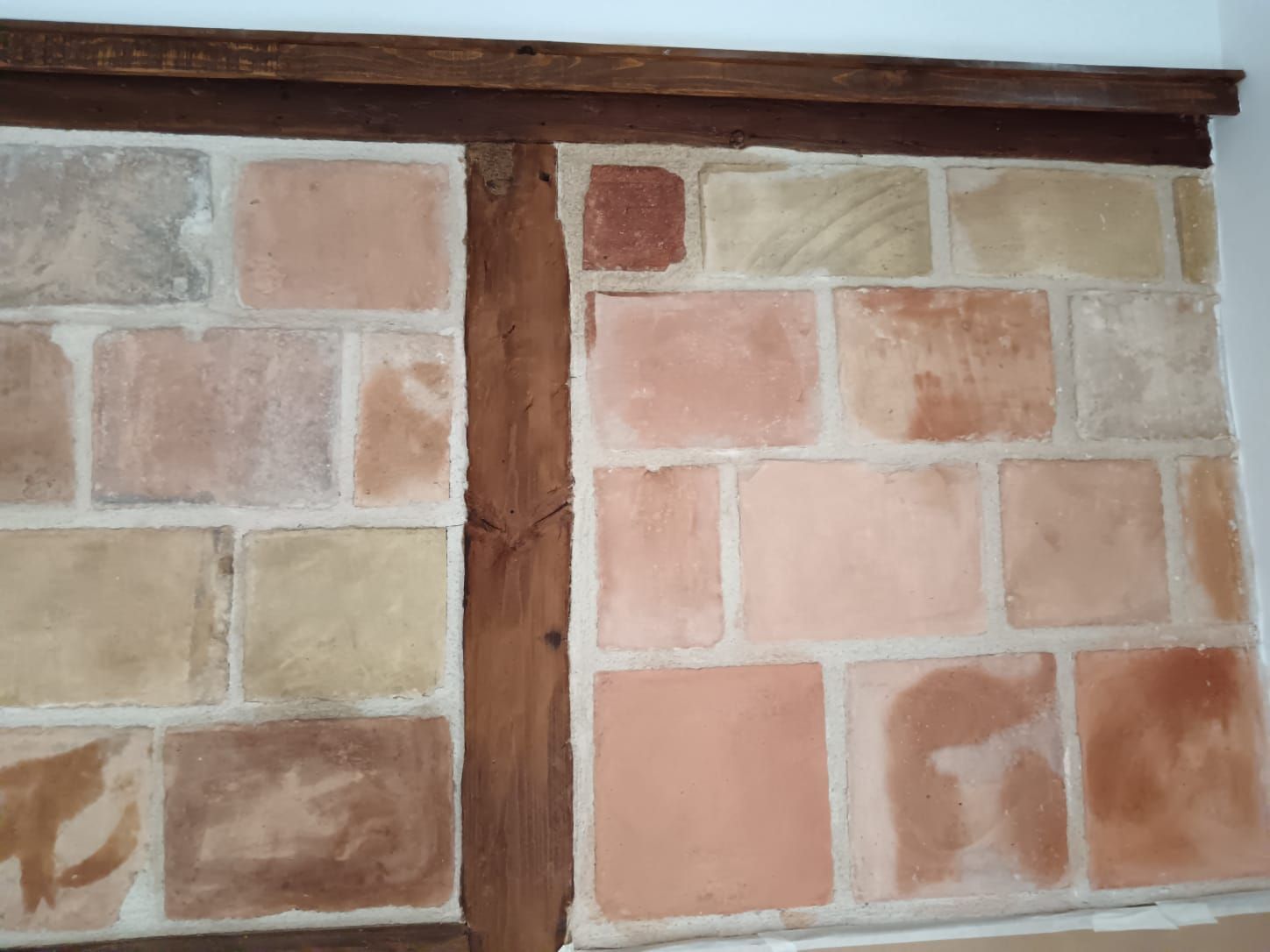 Un primer plano de una pared de ladrillos con vigas de madera.