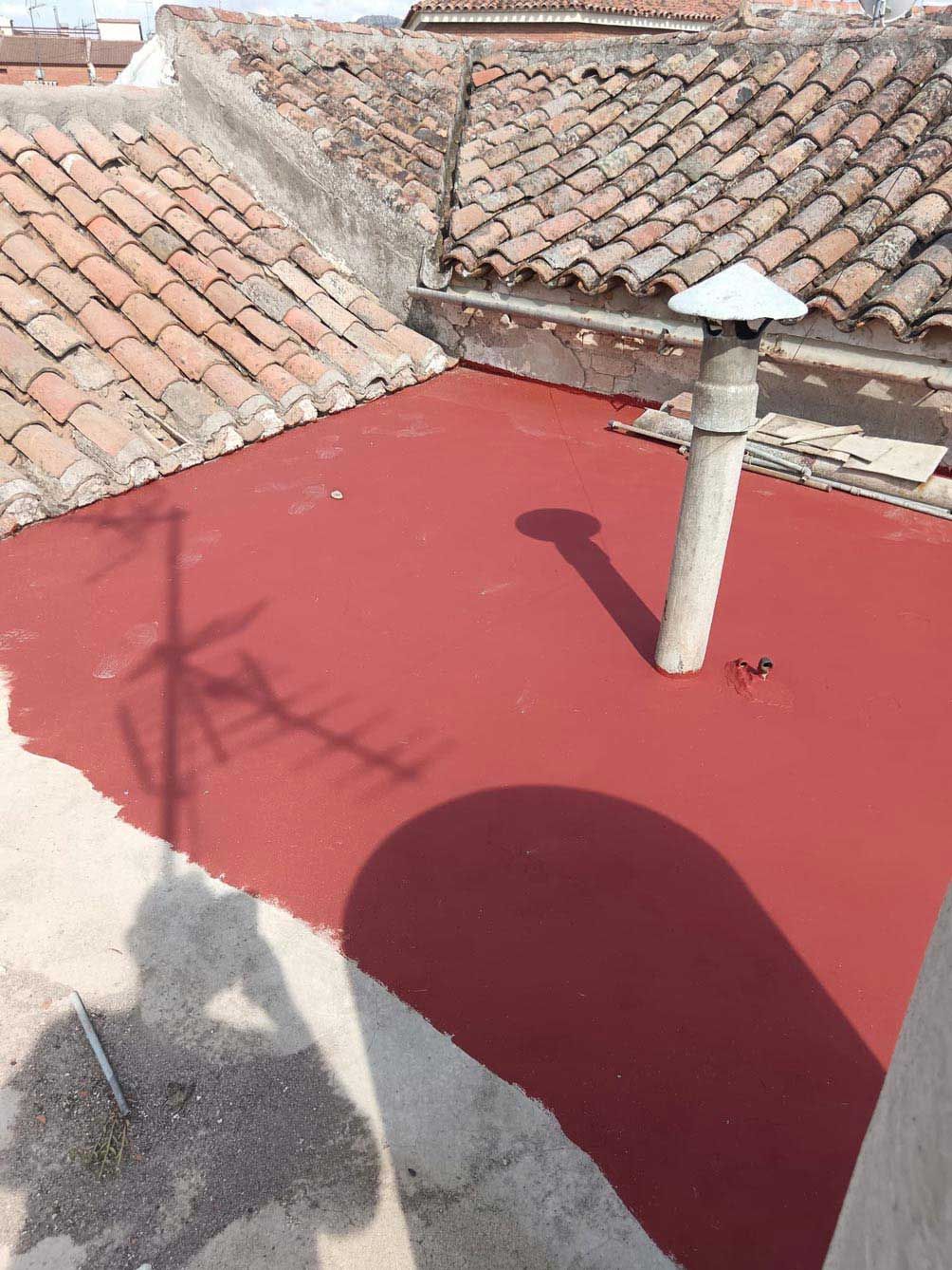Un techo rojo con una chimenea encima