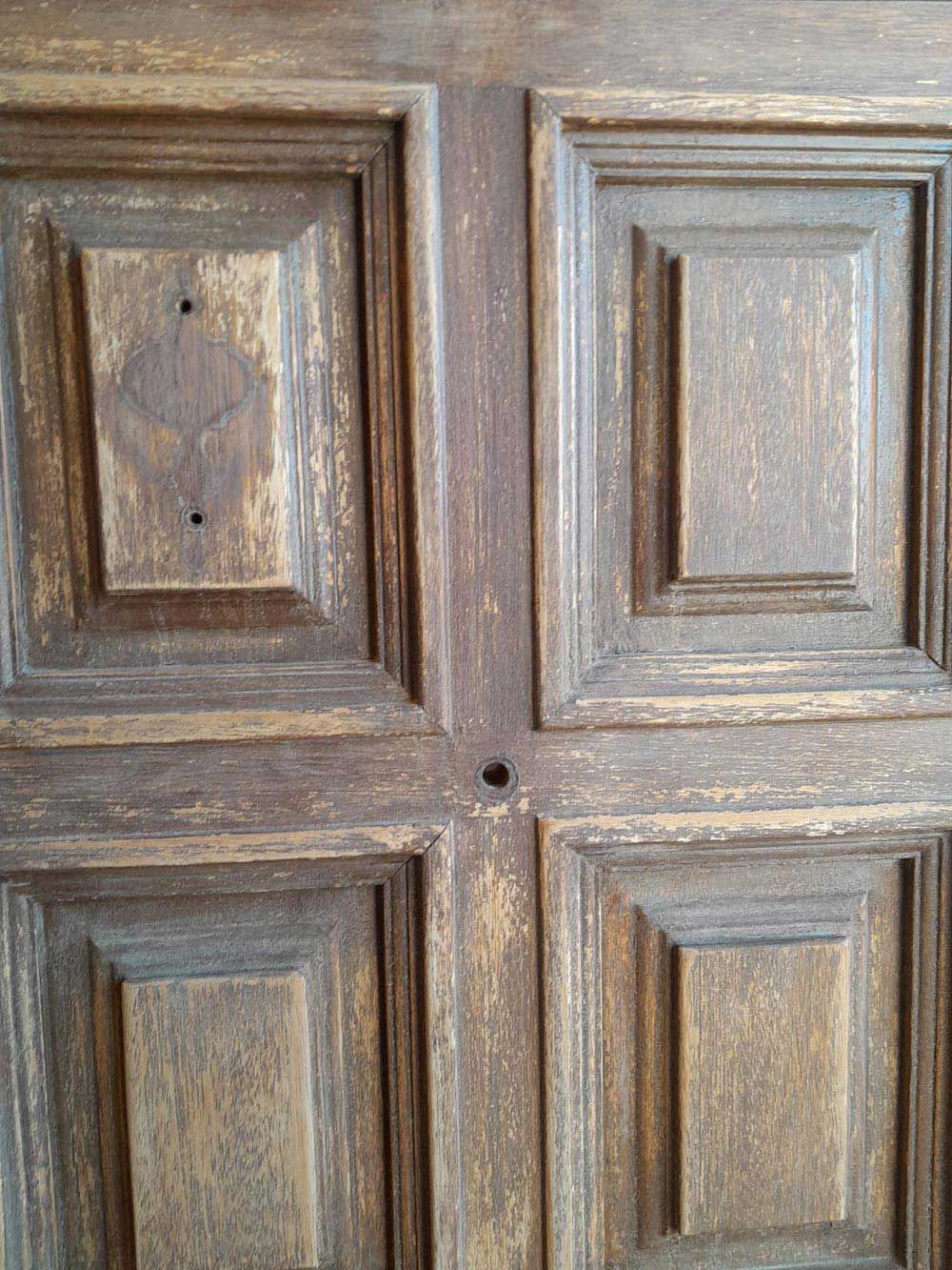 Un primer plano de una puerta de madera con un agujero en el medio.