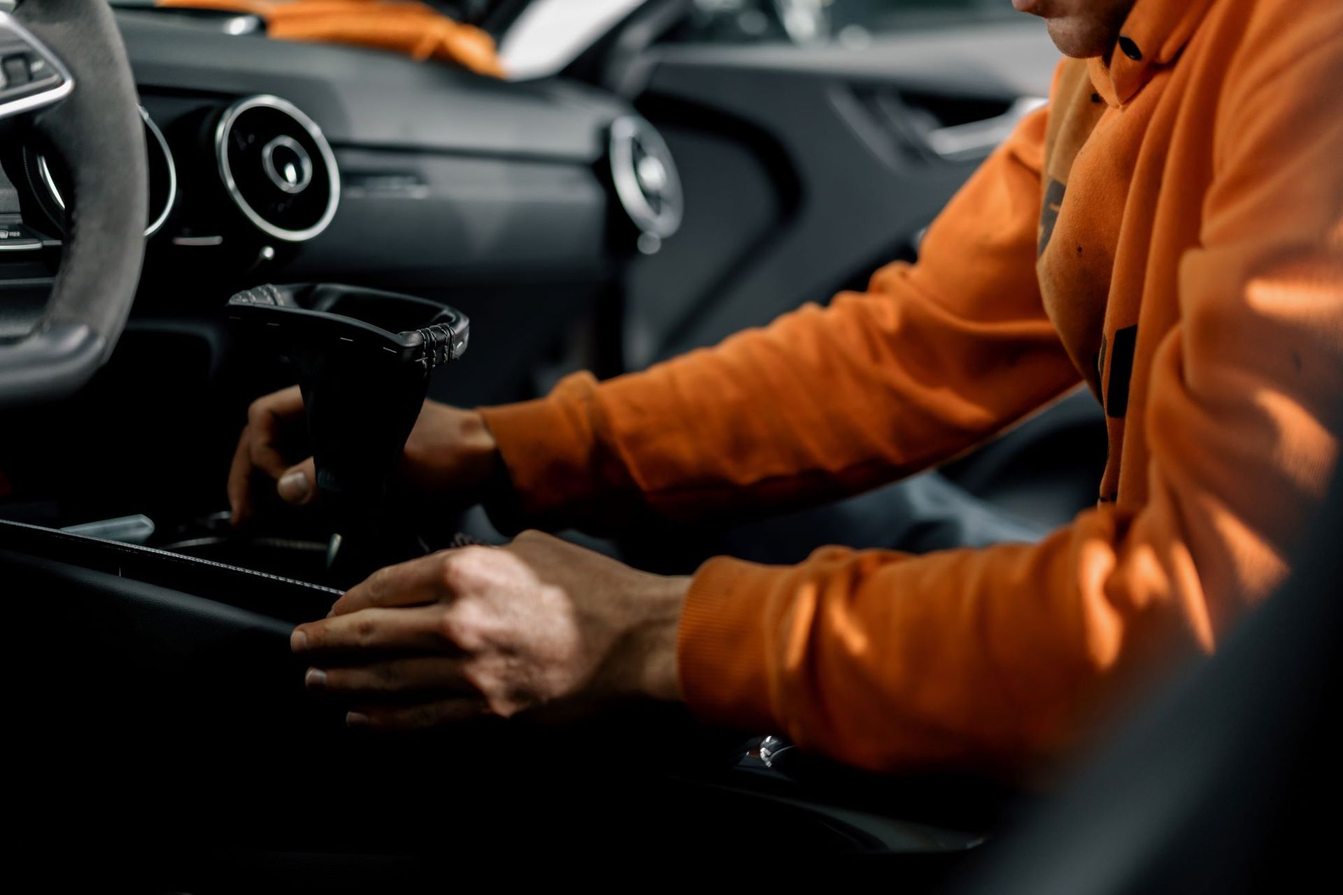 Un homme est assis sur le siège conducteur d'une voiture tenant une tasse de café.