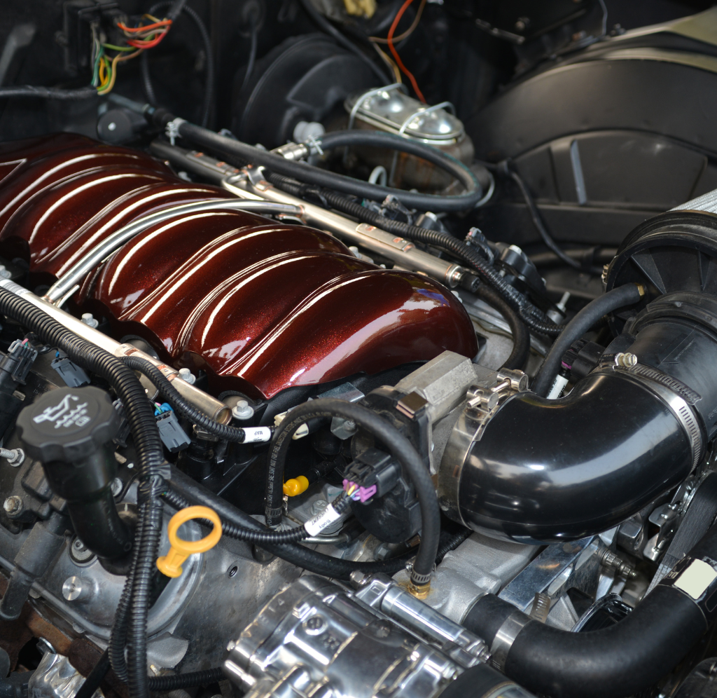 Un gros plan d'un moteur de voiture avec un collecteur d'admission rouge