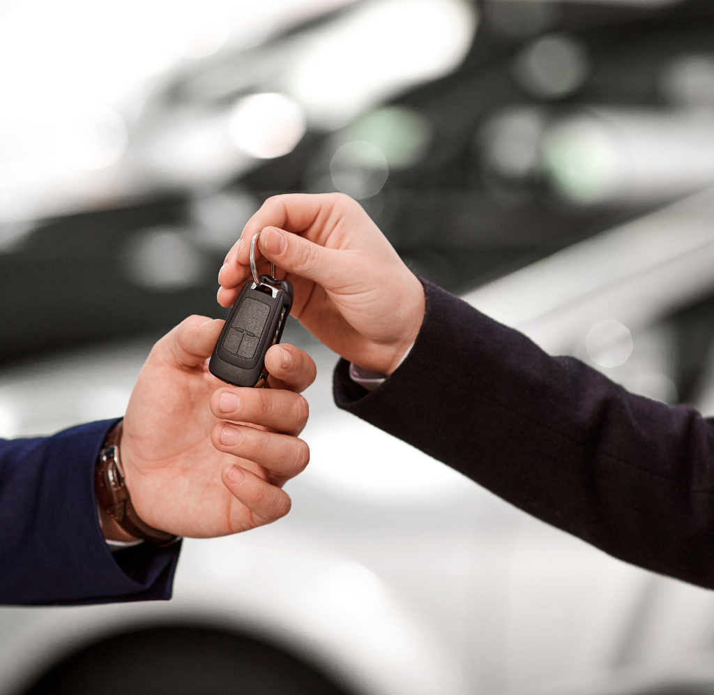 Un homme donne une clé de voiture à un autre homme