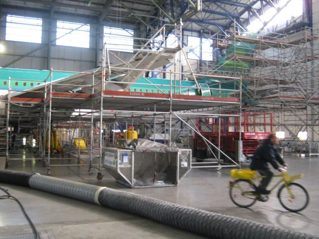 Aile d'avion en réparation dans un hangar, avec des échafaudages