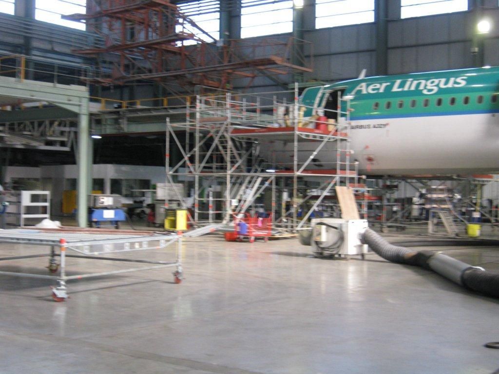 Un avion d'Aer Lingus dans un hangar avec des échafaudages pour la maintenance