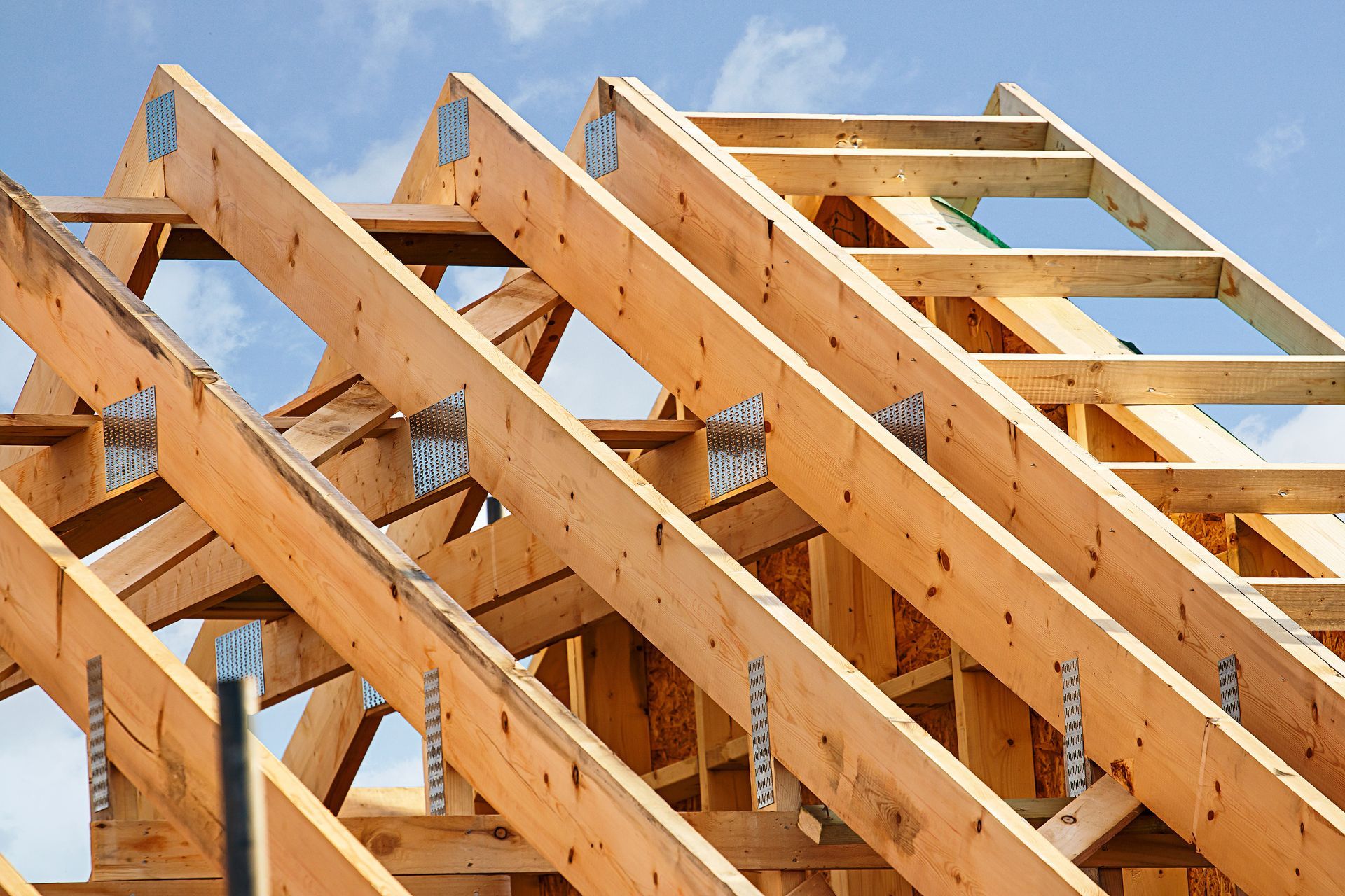 Charpente de toit en bois en construction sur fond de ciel bleu clair