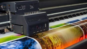 Una impresora grande está imprimiendo una hoja grande de papel.