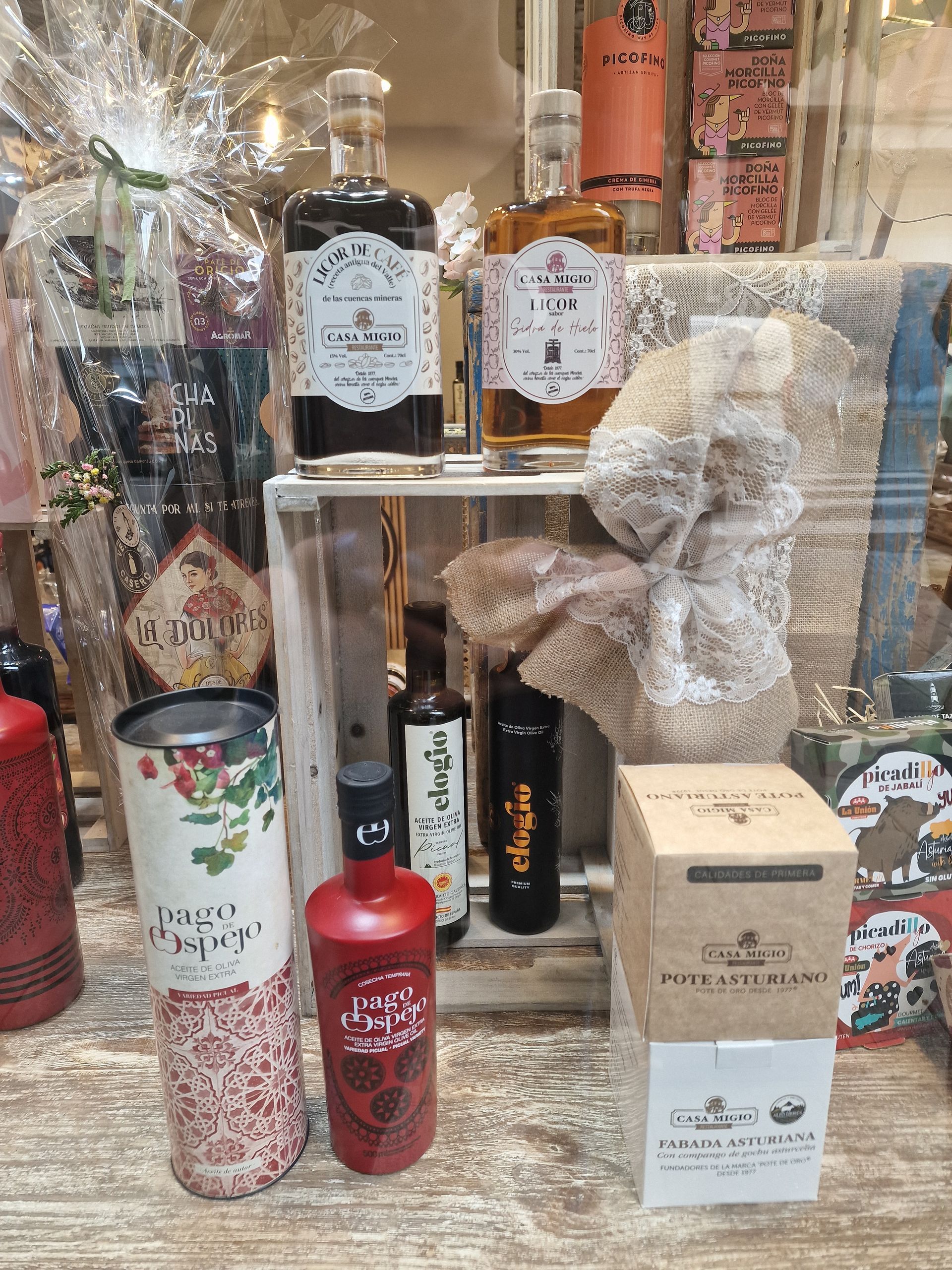 Exhibición de varias botellas de alcohol y artículos de regalo en un escaparate.