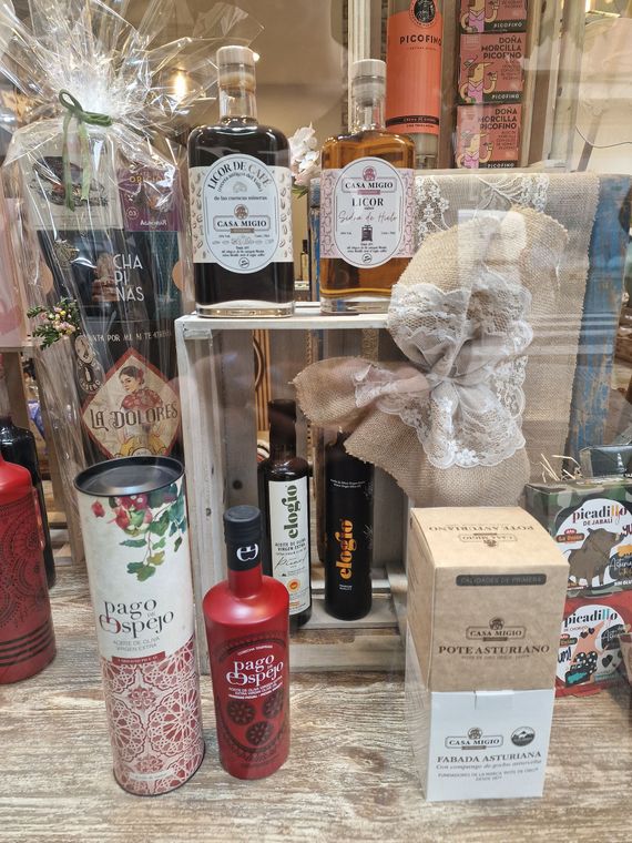Exhibición de varias botellas de alcohol y artículos de regalo en un escaparate.