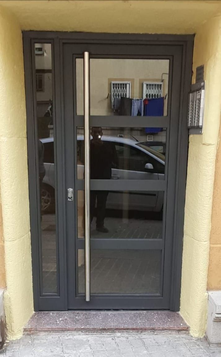 Una puerta negra con manija de acero inoxidable