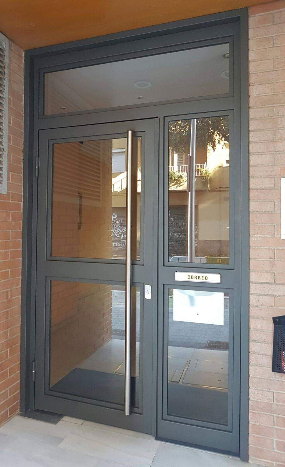 Un edificio de ladrillo con una puerta de vidrio y un buzón.