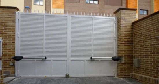 Una puerta blanca está abierta delante de una pared de ladrillos.