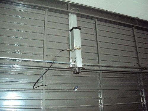 Un poste blanco está fijado al costado de una puerta de garaje.