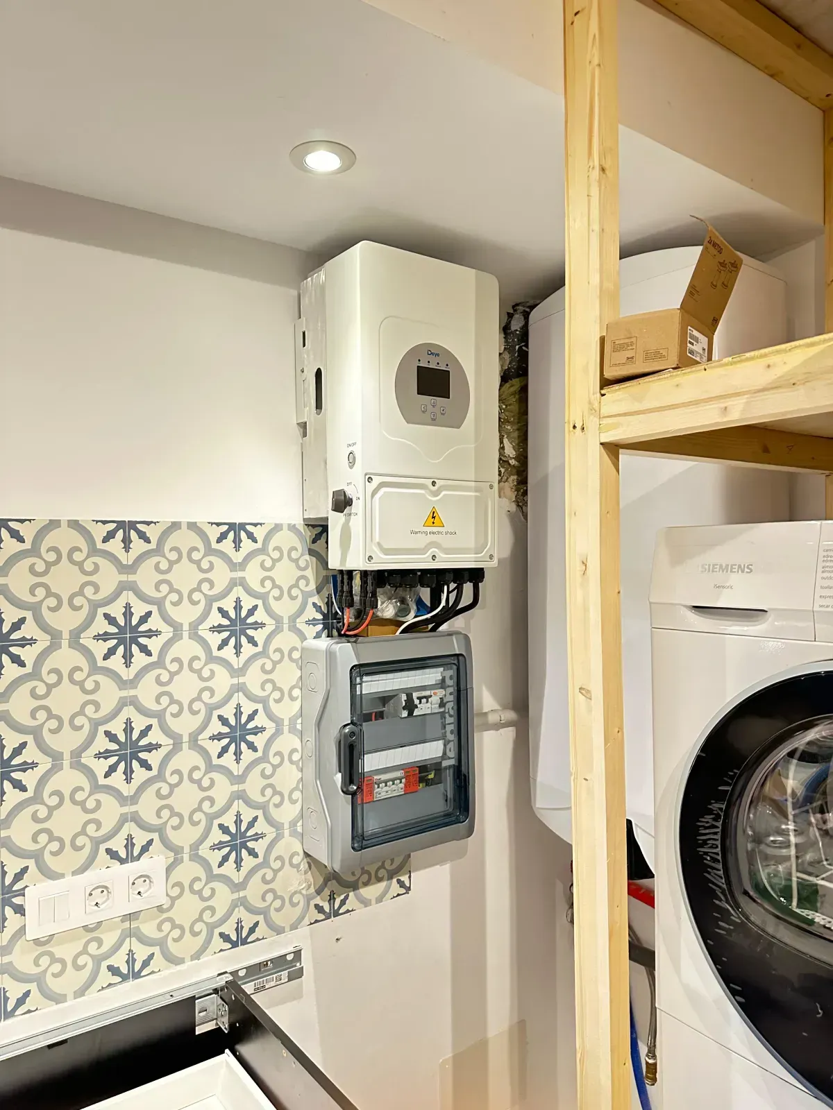 Un inversor solar montado en la pared y una caja de distribución eléctrica ubicados en una habitación