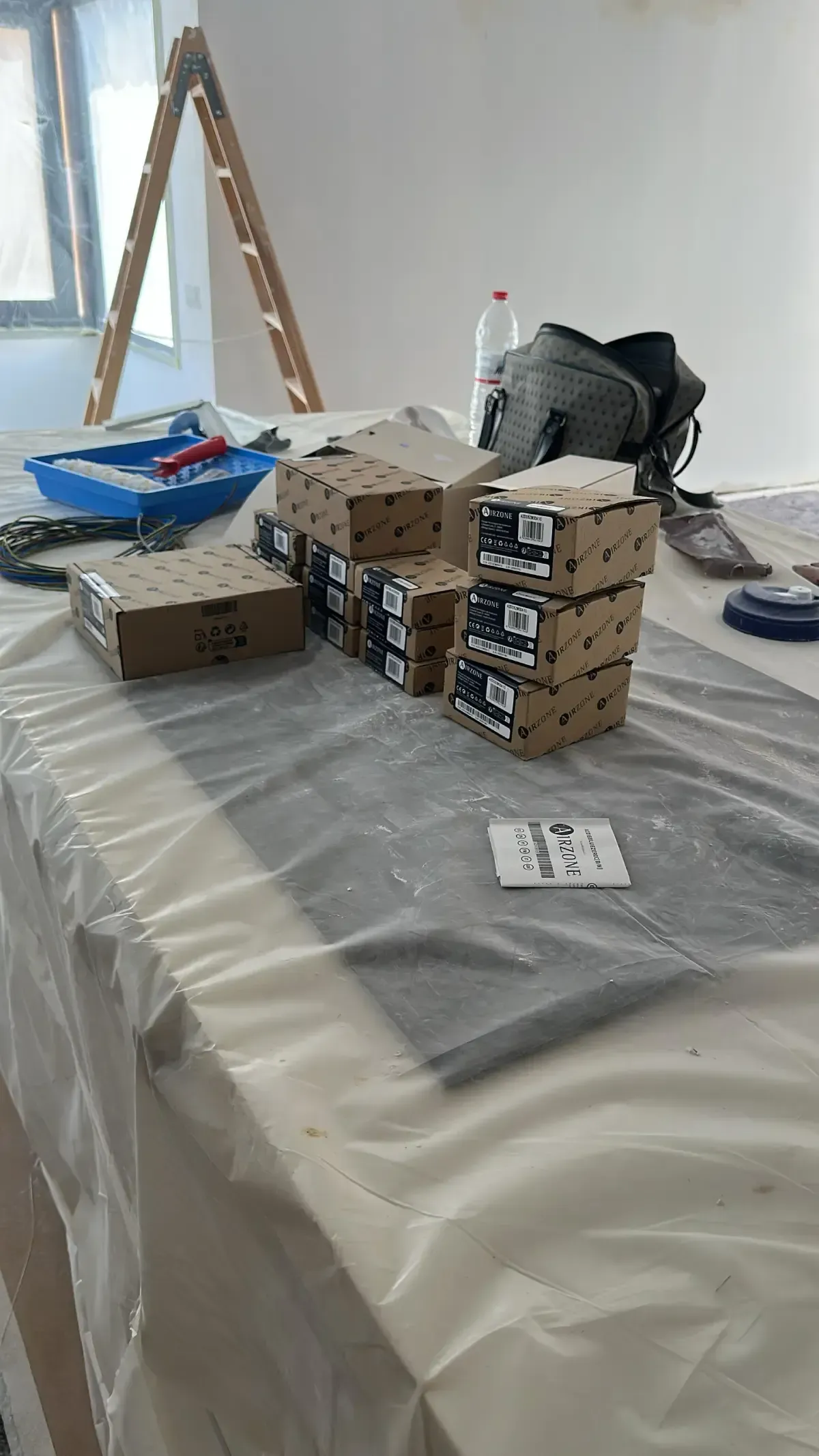 Varias cajas de cartón pequeñas apiladas reposan sobre una mesa cubierta con una lámina de plástico