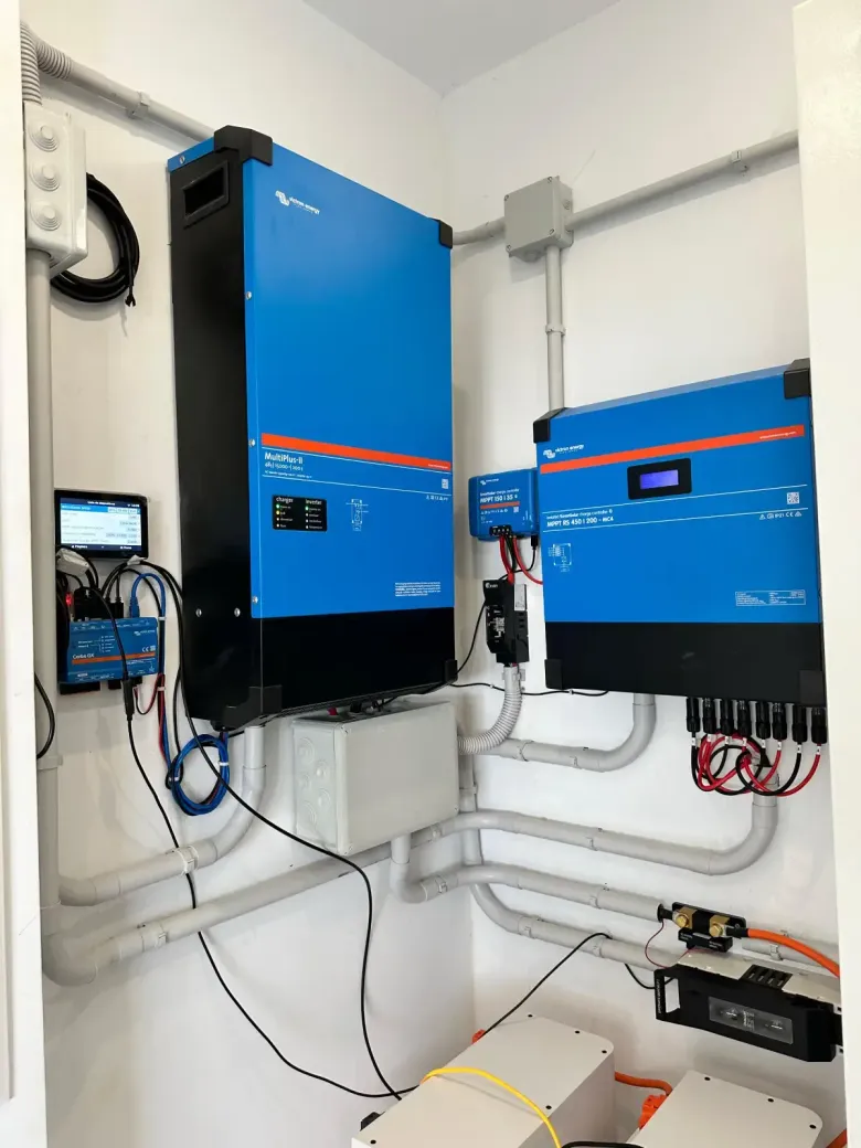 Inversor de potencia y controlador de carga solar Victron Energy de color azul, montados en la pared 