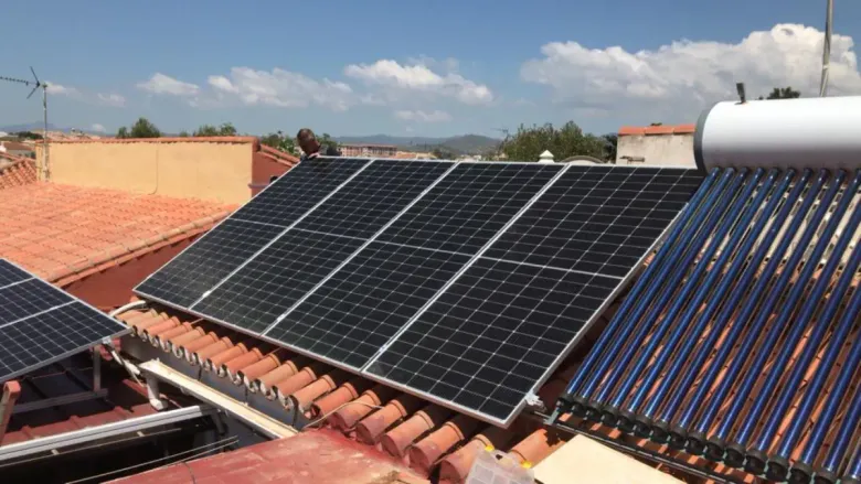 Una azotea con una hilera de tres paneles solares oscuros, un panel más pequeño a la izquierda 