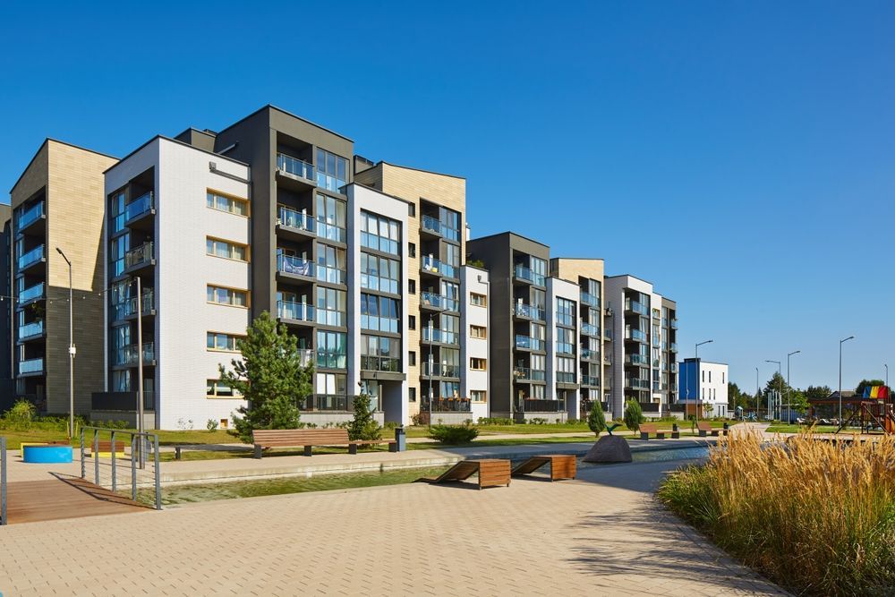 Edificios de apartamentos modernos con balcones contra un cielo azul claro.