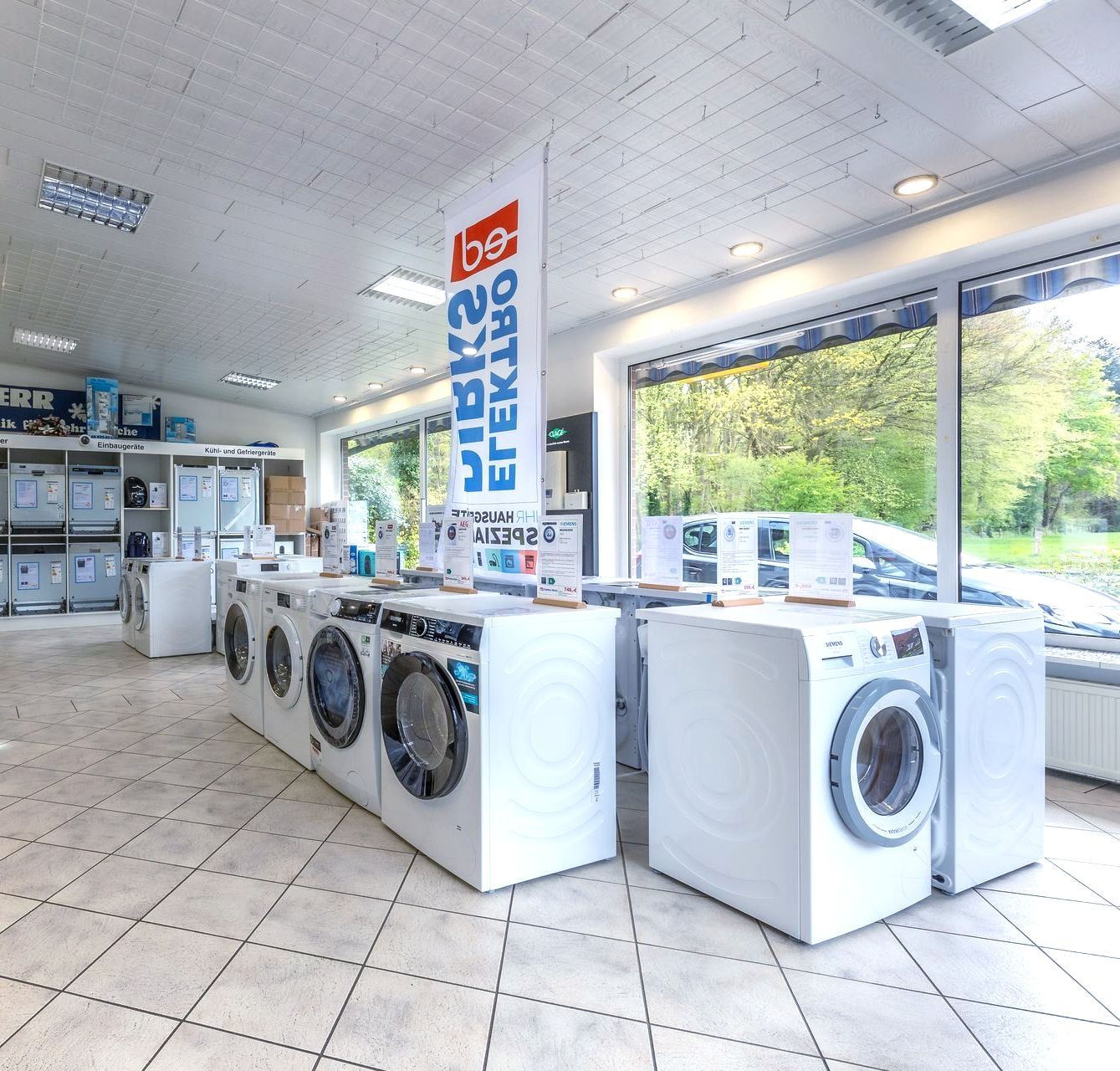 In einem Geschäft stehen mehrere Waschmaschinen aufgereiht.