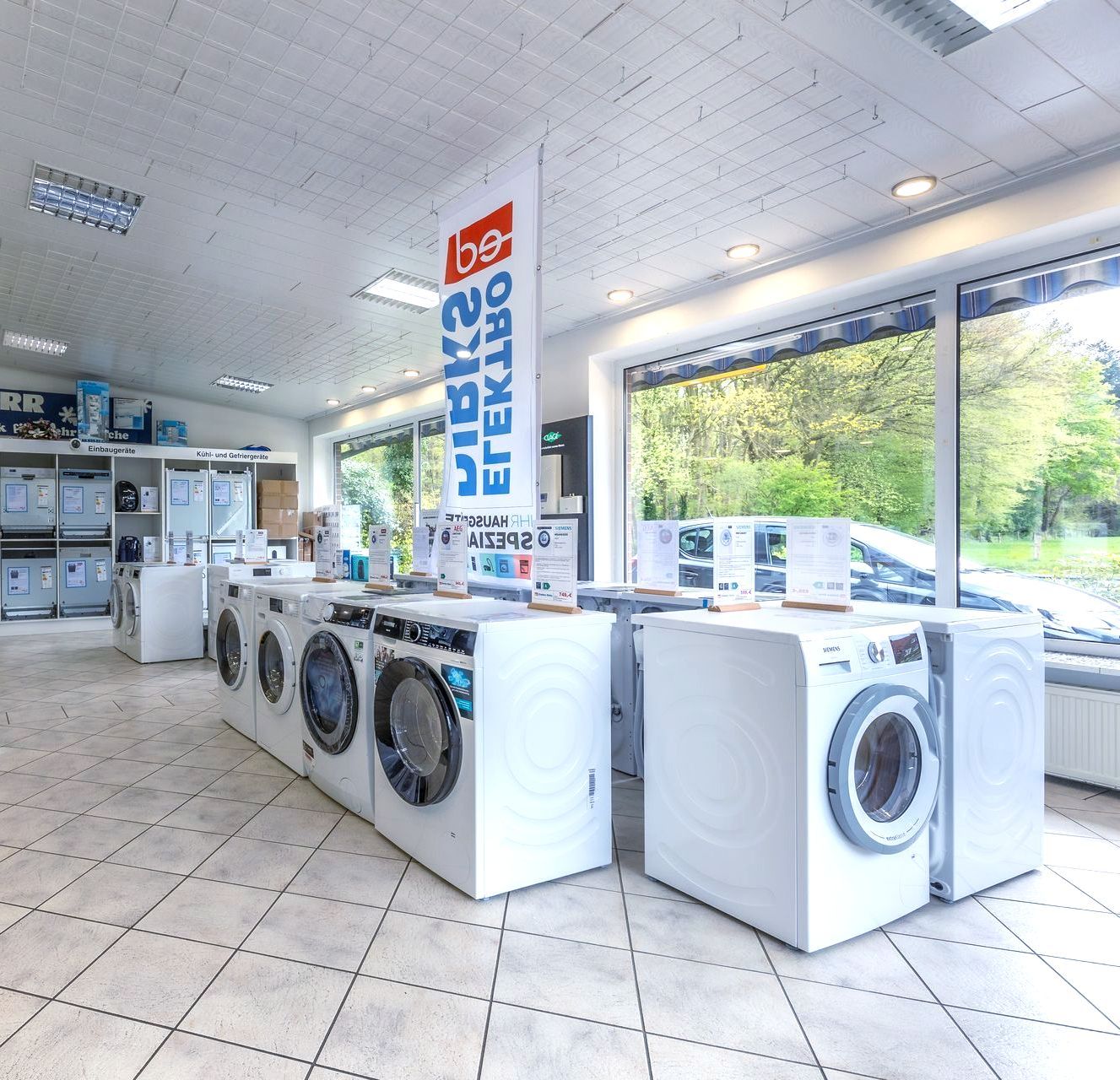 In einem Geschäft stehen mehrere Waschmaschinen aufgereiht.