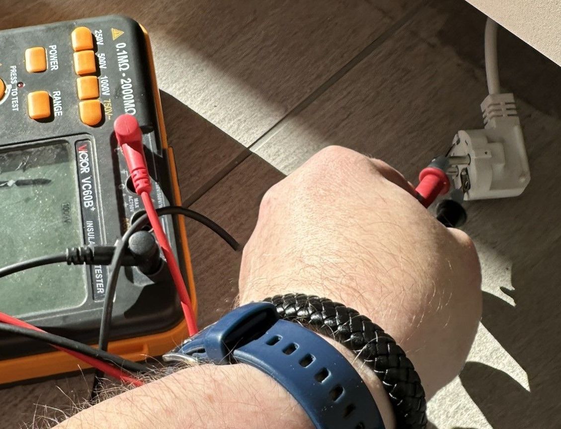 Ein Mann arbeitet mit einem Schraubenzieher an einer Schalttafel.