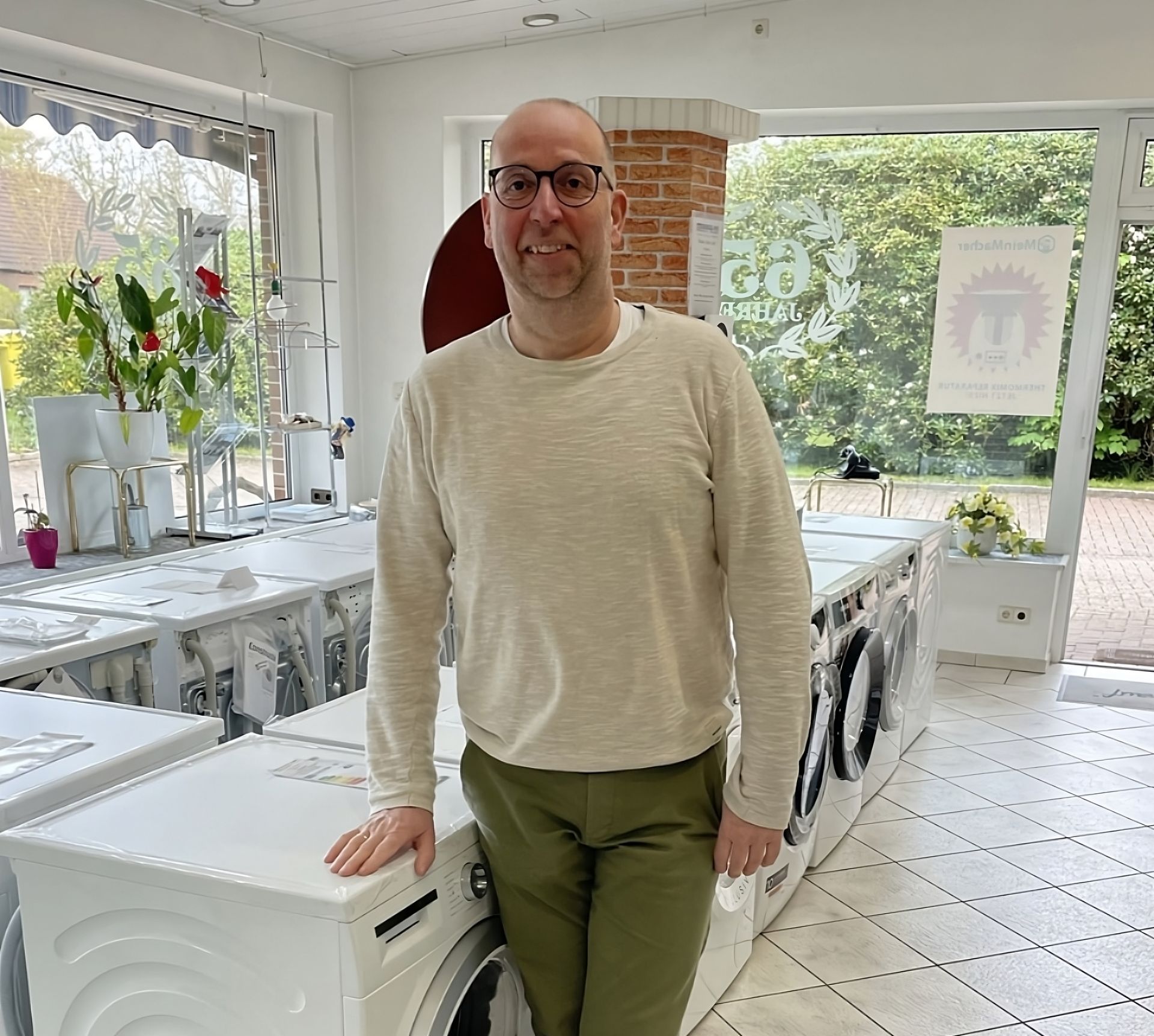 Ein Mann im roten Overall arbeitet an einer Geschirrspülmaschine