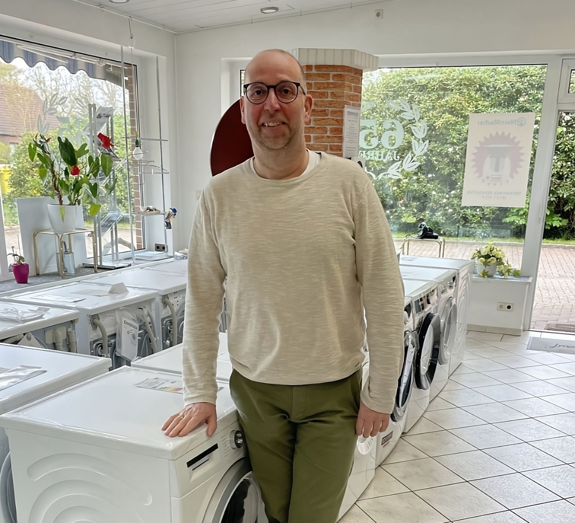 Ein Mann im roten Overall arbeitet an einer Geschirrspülmaschine