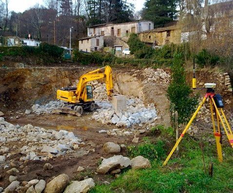 Una excavadora amarilla está trabajando en una zona rocosa