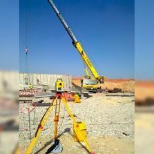 Una grúa está colocada encima de un trípode en un sitio de construcción.