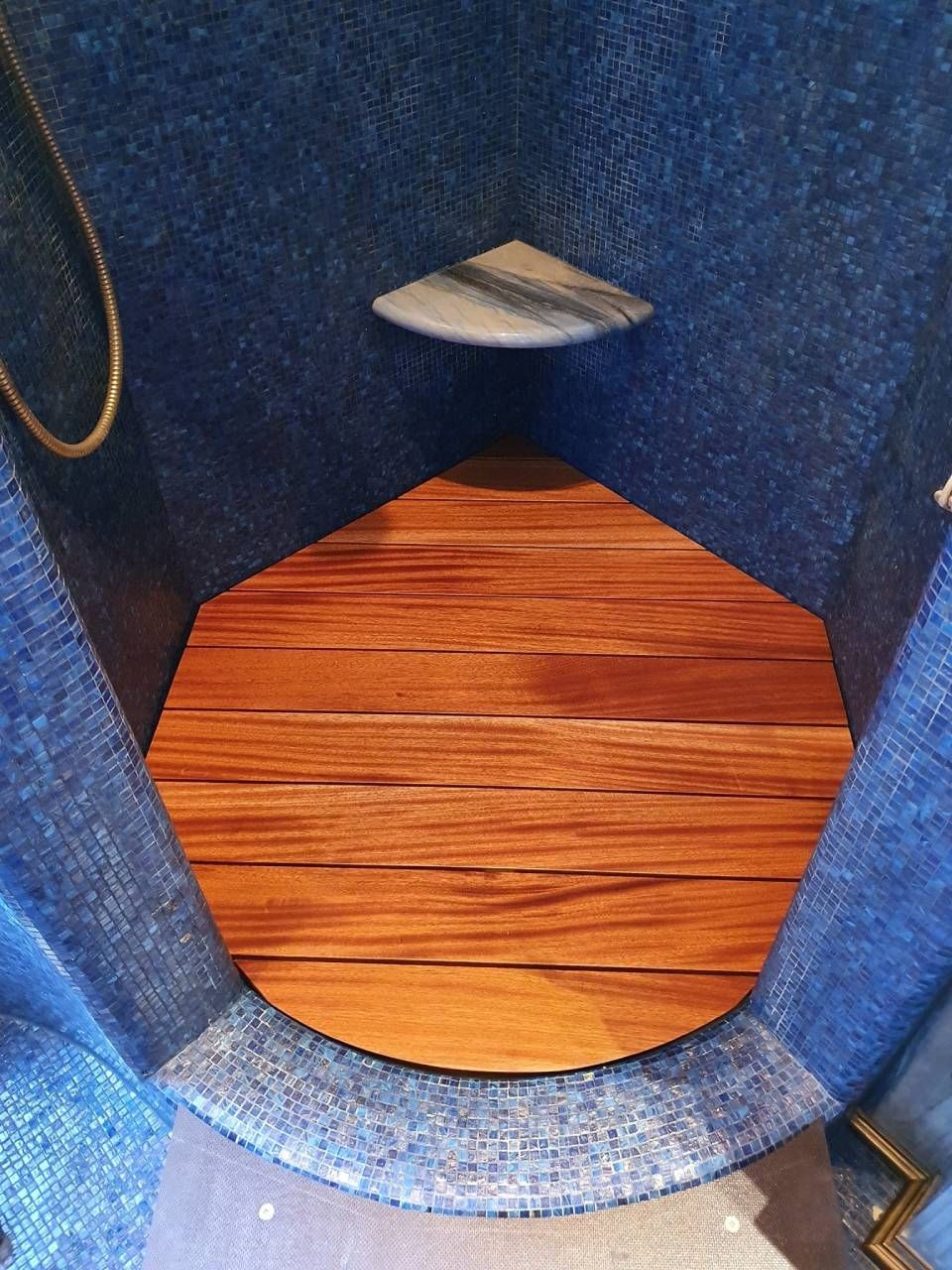 Apertura foderata in tessuto blu con base in legno e un piccolo ripiano bianco all'interno.
