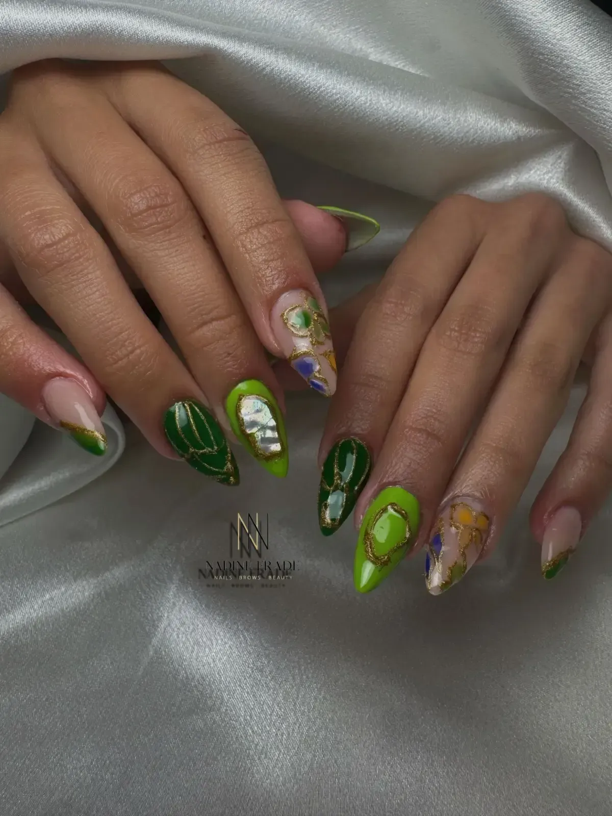 Manos con arte de uñas verde y dorado, que incluye una punta francesa