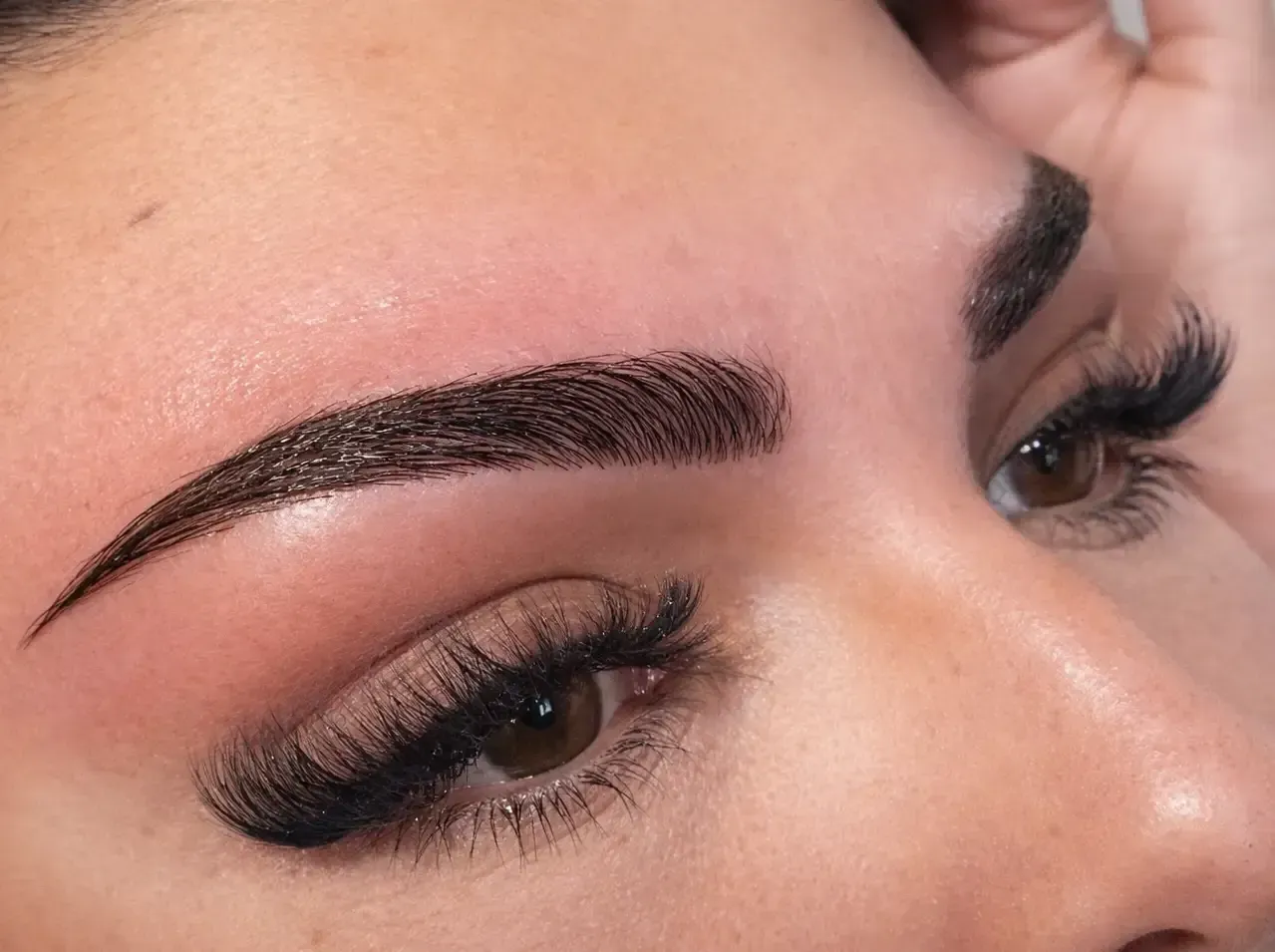 Primer plano del ojo y la ceja de una persona después de un procedimiento cosmético