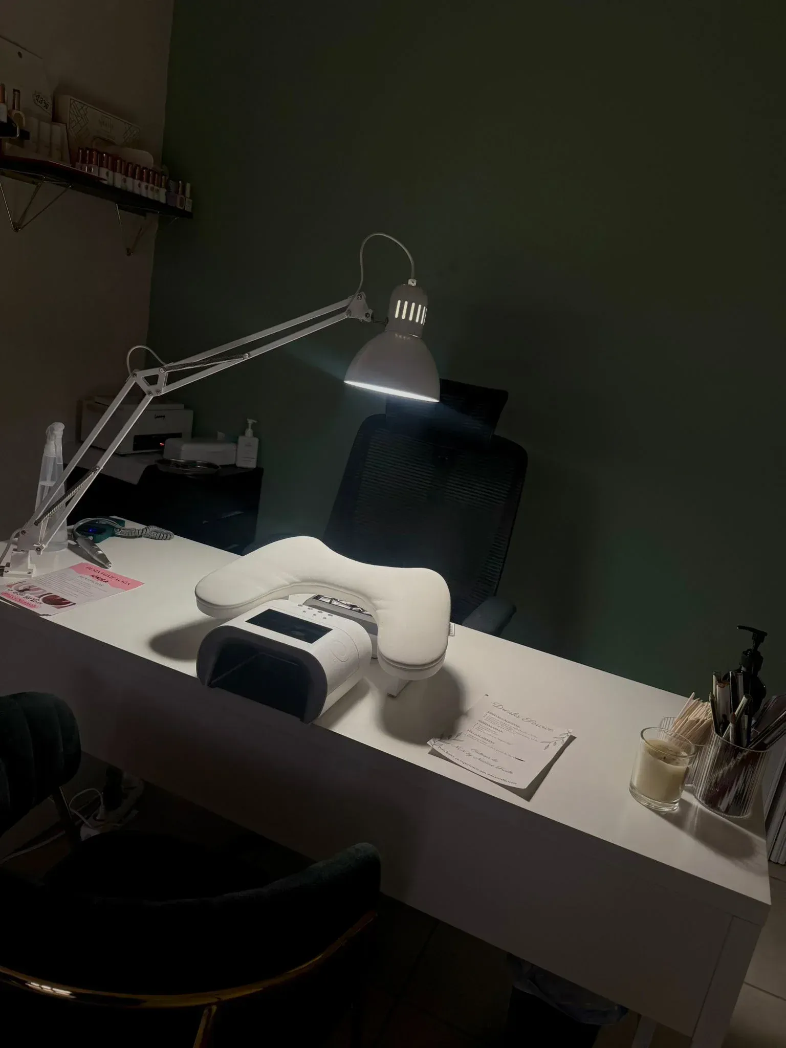 Uñas cuidadas con detalles dorados y acentos granates, sobre un fondo de seda blanca.