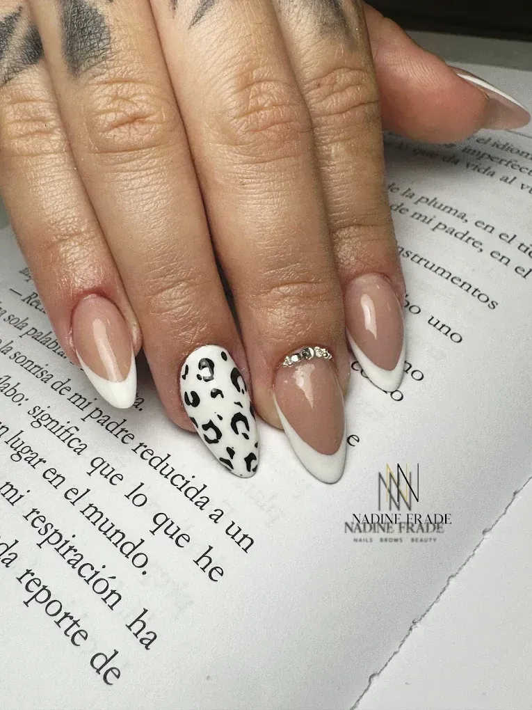 Mano con uñas en forma de almendra, algunas puntas francesas, un estampado de leopardo