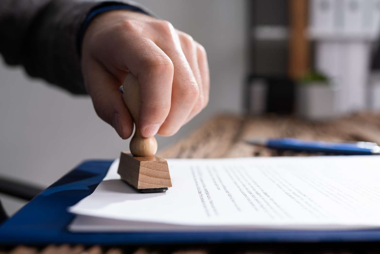 Una persona está sellando un documento con un sello de madera.